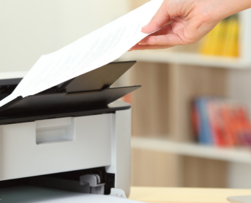 Hand pulling paper from a Canon printer