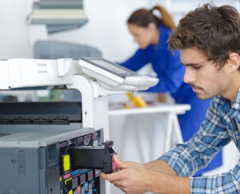 Office employees replacing equipment in a printer