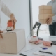 Close up of worker taping a cardboard box in office mailing room
