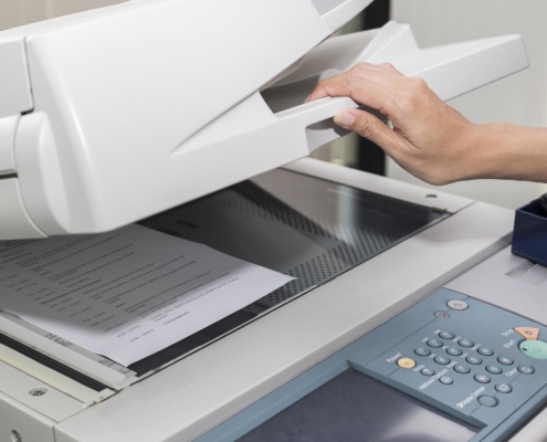 Close up of hand closing copier machine to scan a document