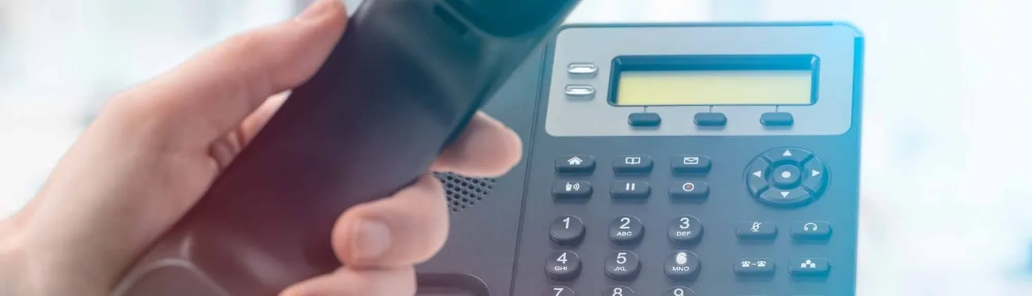 A hand holding a VOIP phone