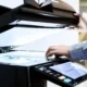 A business person's hand placing a document into the printer