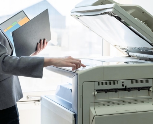 Image of a business person using a commercial printer and scanner.