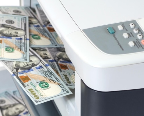 Image of money laying on top of a printer.