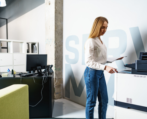 woman in blue jeans using office printer