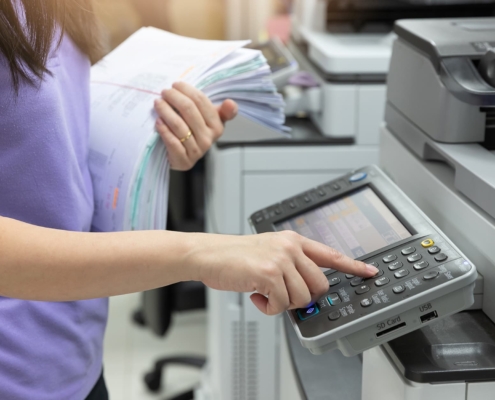 Employee pressing buttons on a printer control panel