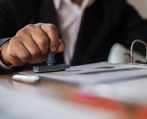 Image of a business person stamping a document.