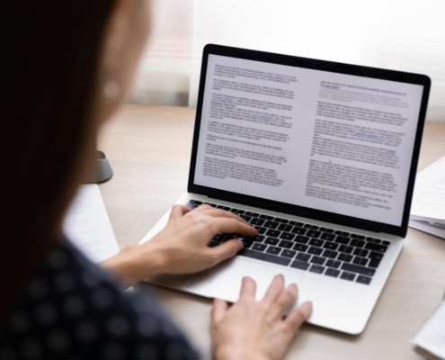 Image of a person using a laptop to work on a document.