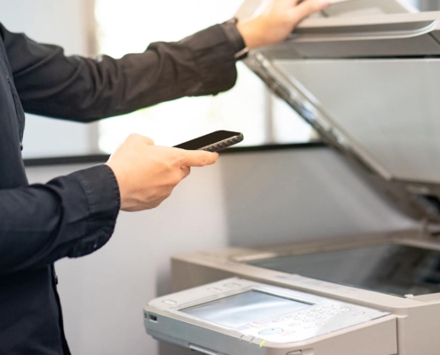 Image of a person using their mobile phone to print from the office.