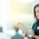 A woman looking at a tablet and smiling