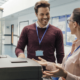 Two workers smiling and talking by the copier