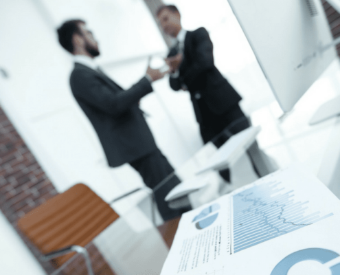 Two men discussing business near a printer