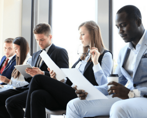 Five workers sitting in chairs and looking at a piece of paper