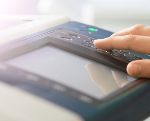 Close up of a hand pressing buttons on a printer control panel