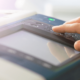 Close up of a hand pressing buttons on a printer control panel