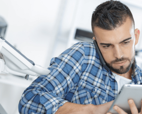 A man holding a phone and writing down notes