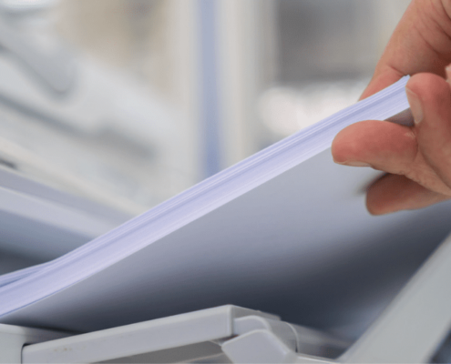 Close up of hand taking paper from printing tray