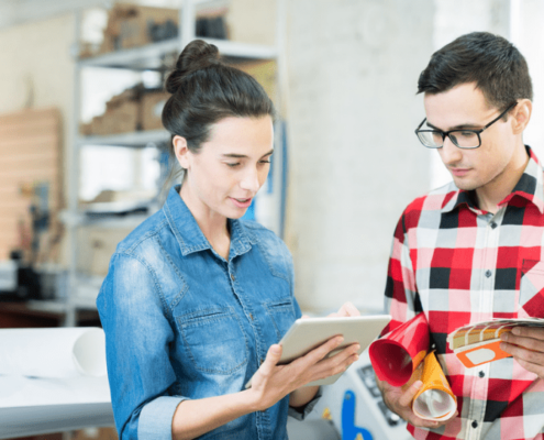 Two workers staring at a tablet