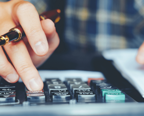 Image of a man crunching numbers on a calculator