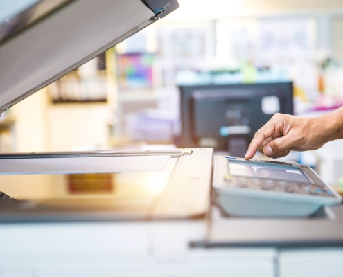 Side view of person using office printer with open copier top