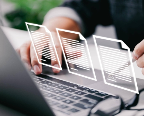 Close up of office worker signing illustrated digital document in front of laptop