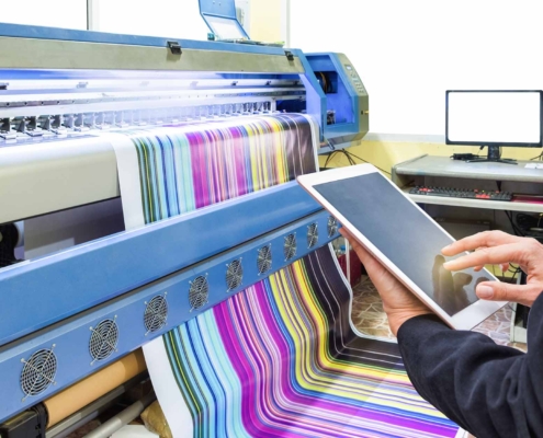 Large printer and person working on tablet