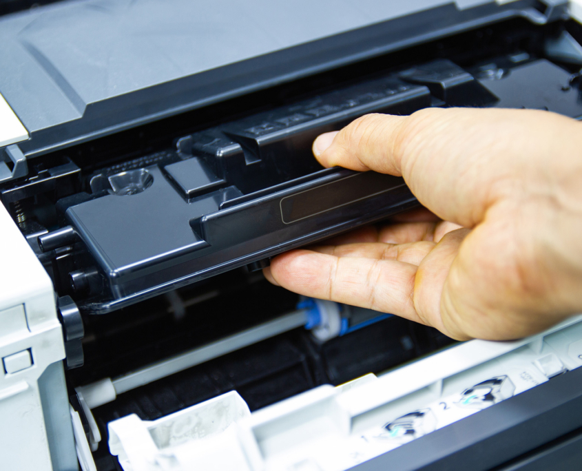 Close up of a hand tinkering with printer parts