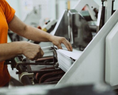 Close up shot of worker's hand preparing carton for printing in a modern printing house